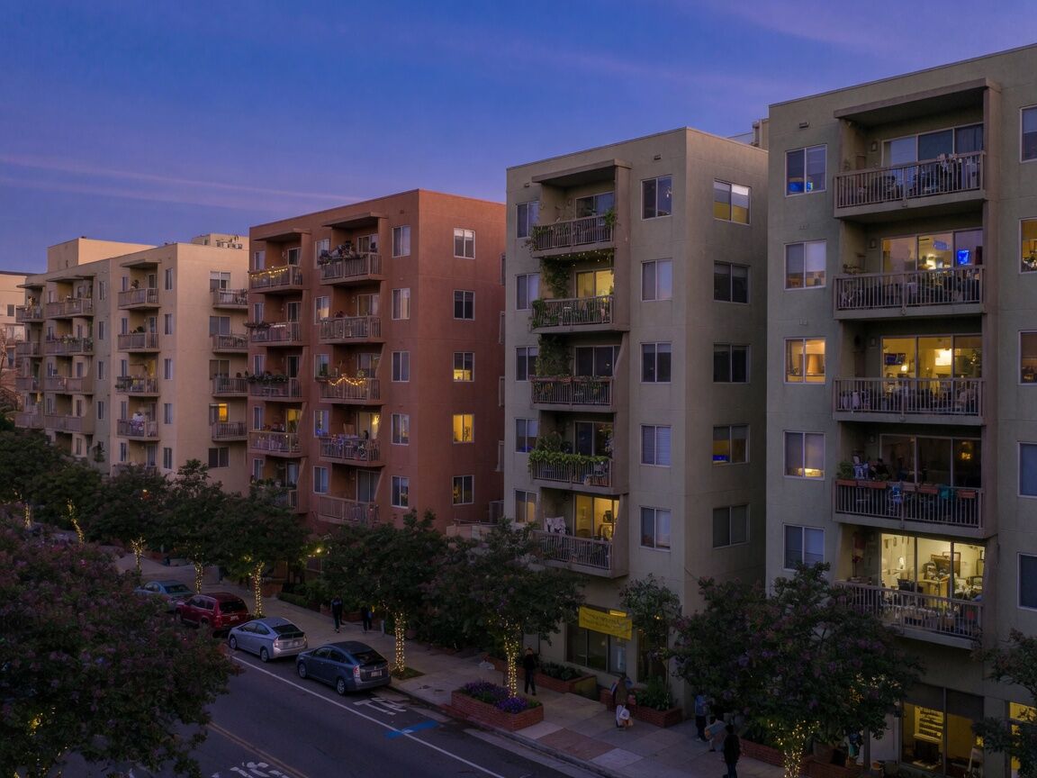 Mid-rise residences with balconies at blue hour.